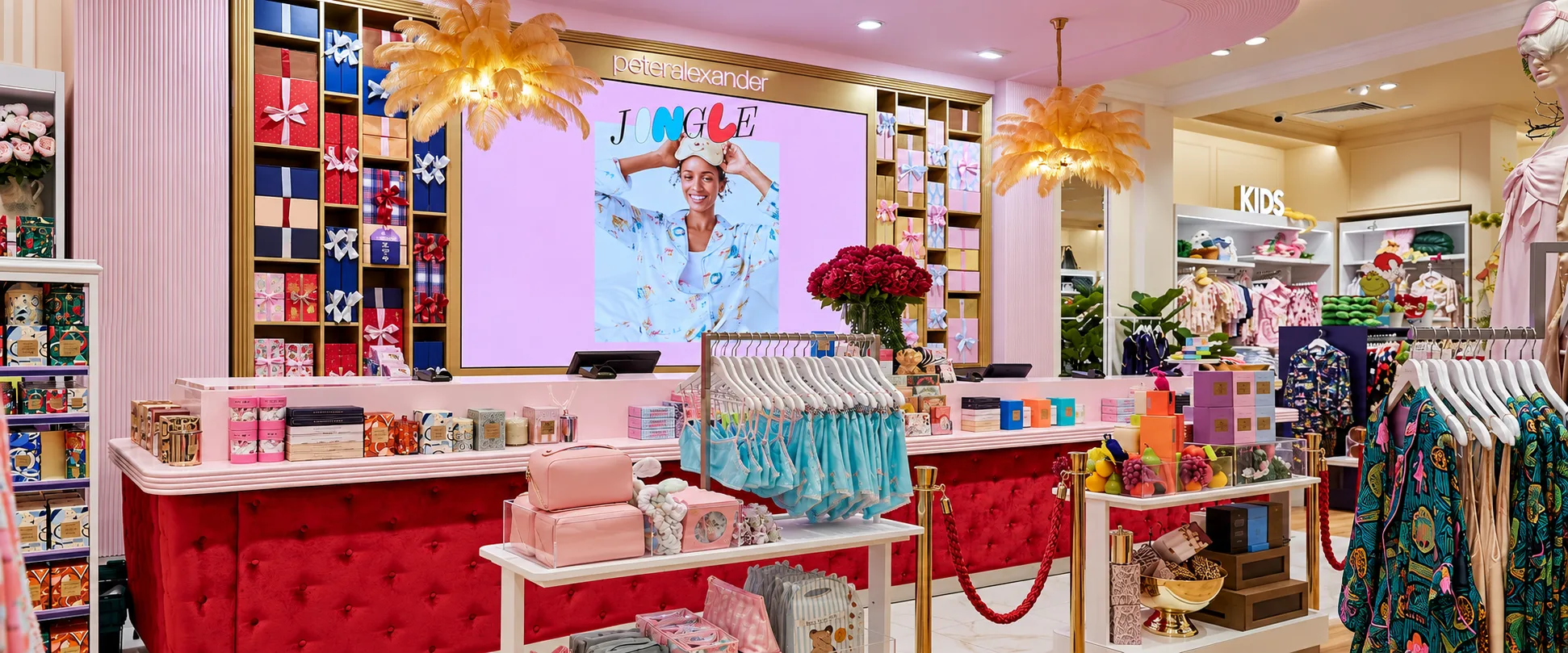 Peter Alexander store with a pink and gold gift wall behind a red velvet counter